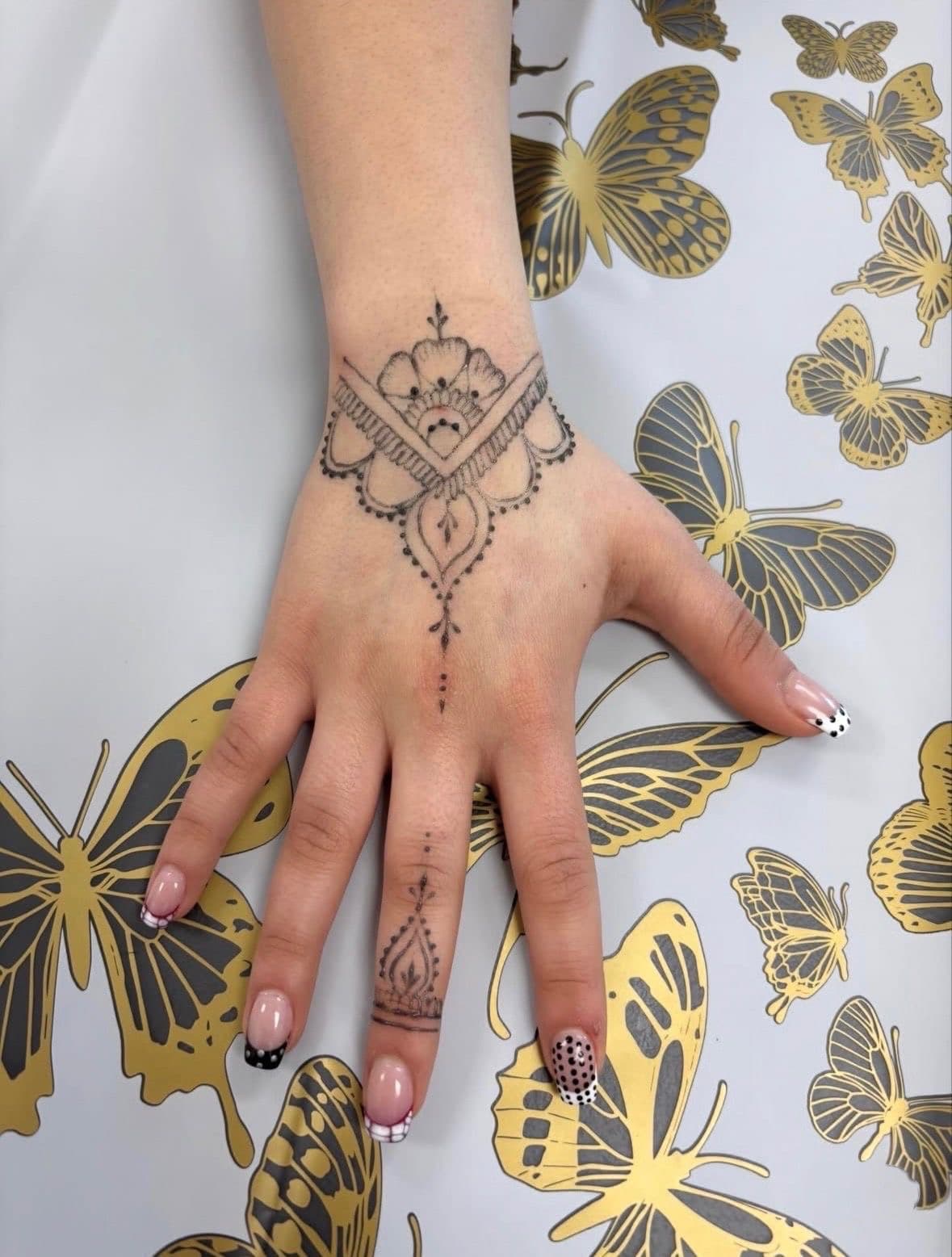 Wrist cuff design in jagua with mandala and a small finger motif on butterfly fabric